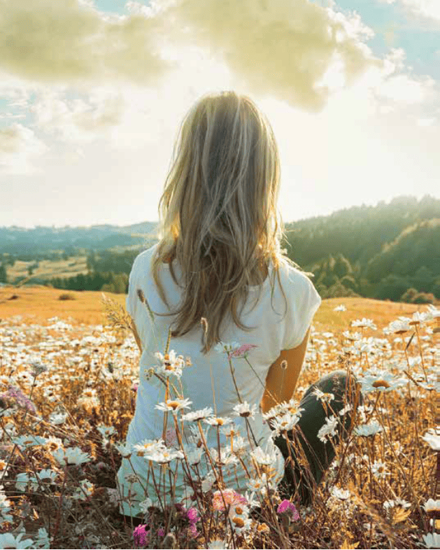 donna seduta in un prato tra i fiori